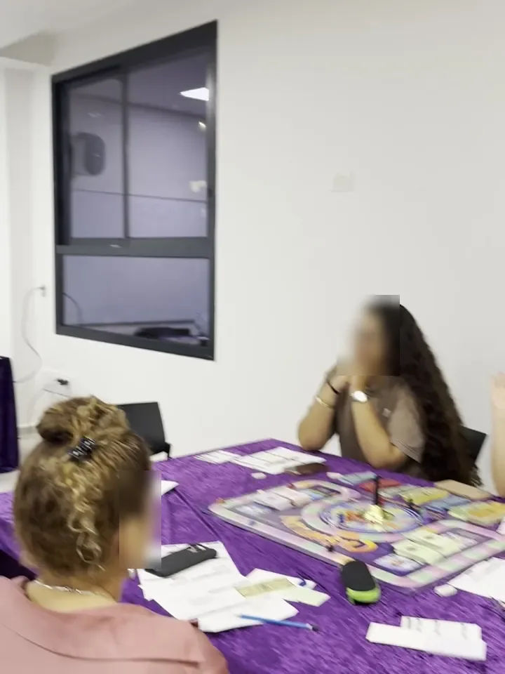 Participants playing at a table with the game board and cards